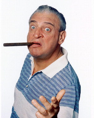Rodney Dangerfield performing stand-up comedy on stage with audience laughing