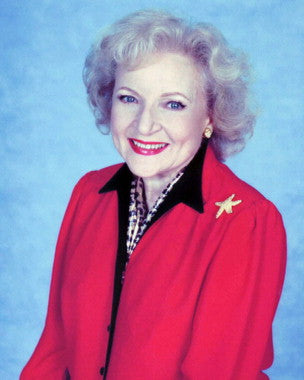 Betty White Table Lamp in a cozy reading corner, illuminating a book.