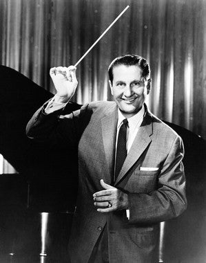 Lawrence Welk performing live with his band in a vintage setting.