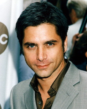 Close-up of a John Stamos poster featuring iconic images for fans