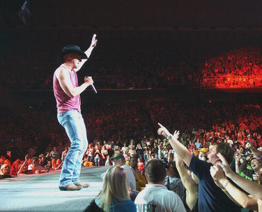 Kenny Chesney performing live on stage with energetic crowd
