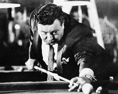 Jackie Gleason performing in a classic comedy sketch, showcasing his unique style and charm.