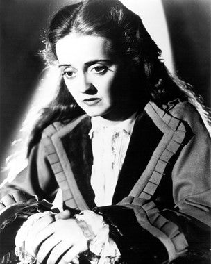 Bette Davis in a classic film scene, showcasing her iconic style and presence.