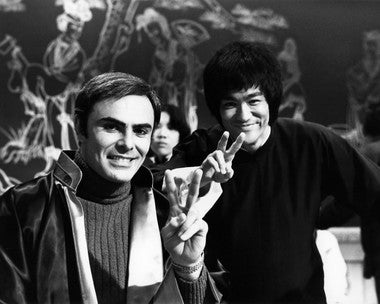 Bruce Lee performing martial arts kicks in Enter the Dragon scene