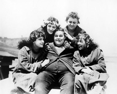 Roscoe Arbuckle in a classic silent film scene, showcasing his comedic talent and unique style.