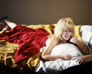Model showcasing vintage-inspired Bardot lingerie in a chic bedroom setting