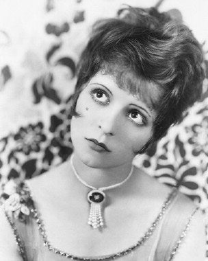 Close-up of Clara Bow organic skincare bottles and makeup products arranged on a white background, highlighting natural ingredients.