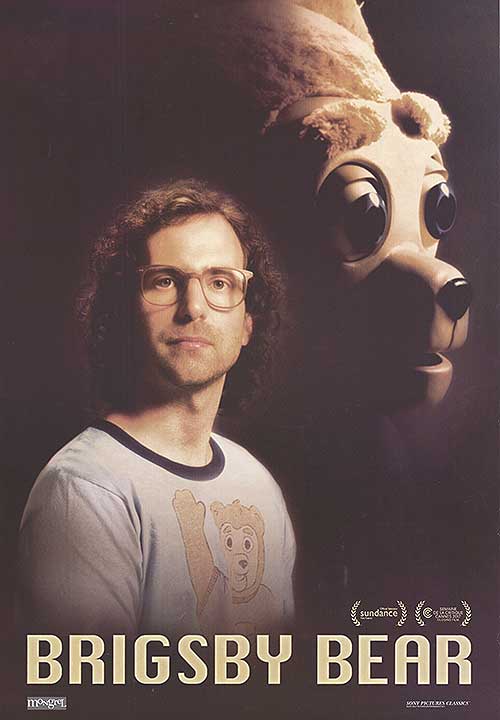 Front view of Brigsby Bear plush toy sitting upright on a child's bed