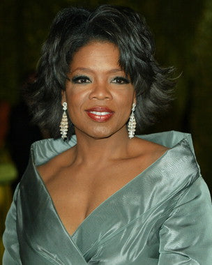 Oprah Winfrey speaking at a motivational event, inspiring the audience.