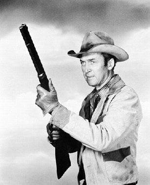 James Stewart as Will Lockhart standing in the desert with rifle – classic western movie scene