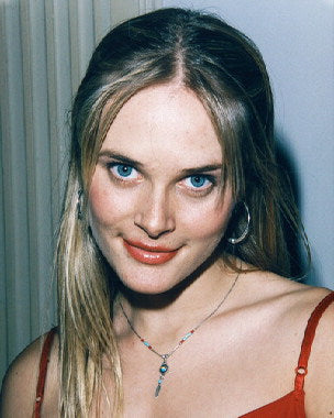 Woman applying anti-aging serum on her face, showing youthful skin