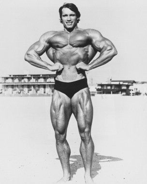 Arnold Schwarzenegger demonstrating muscle training techniques in a gym setting.
