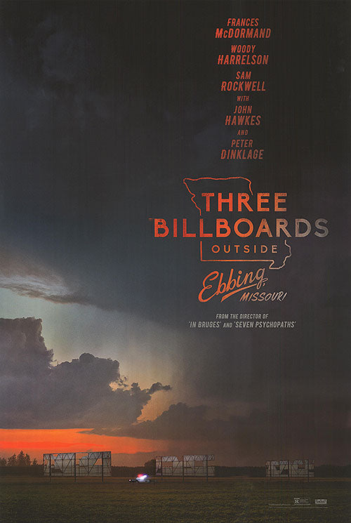 Frances McDormand standing defiantly in front of the three billboards in a pivotal scene from the crime drama film.