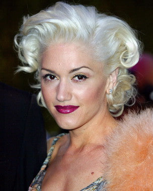 Gwen Stefani performing live on stage with fans cheering, capturing the energy of the concert.