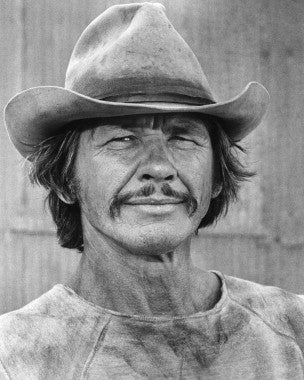 Charles Bronson strategizing in a tense moment of Breakout movie.