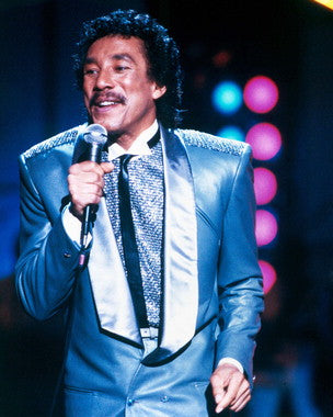 Smokey Robinson performing live on stage with a vintage microphone
