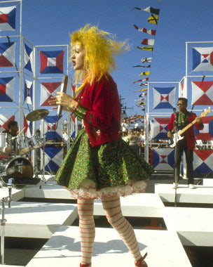 Cyndi Lauper performing live on stage with colorful lights