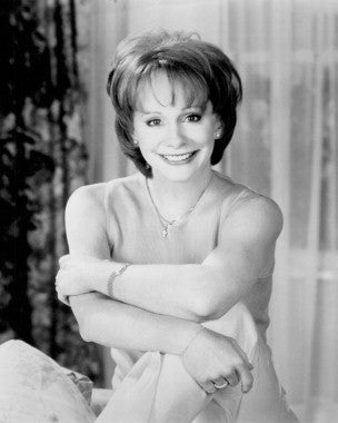 Reba McEntire performing live on stage at a concert.
