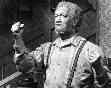 Redd Foxx in a vintage Sanford and Son t-shirt, showcasing classic sitcom merchandise.